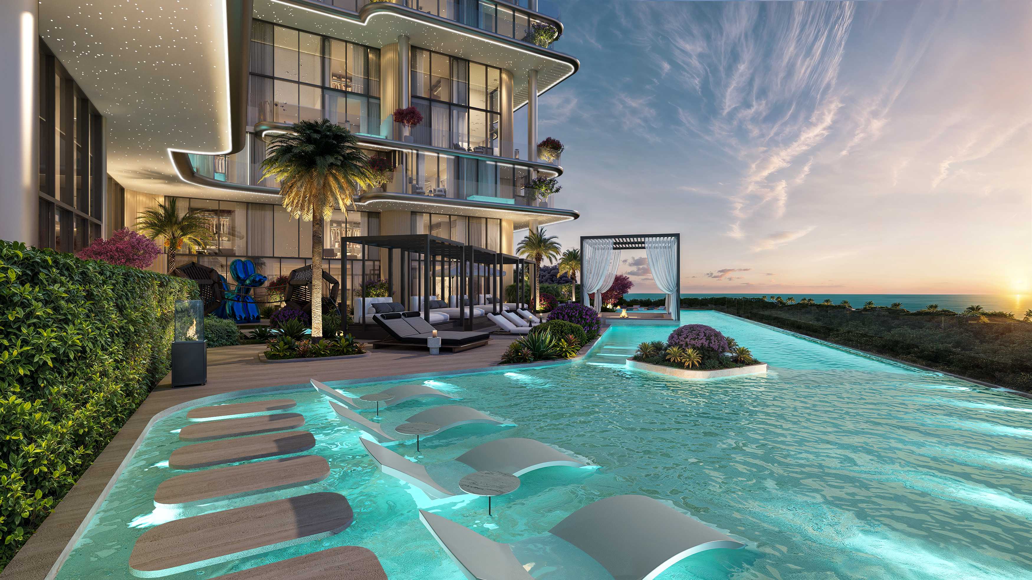 Pool with in-water loungers and cabanas glowing at sunset beside the tower