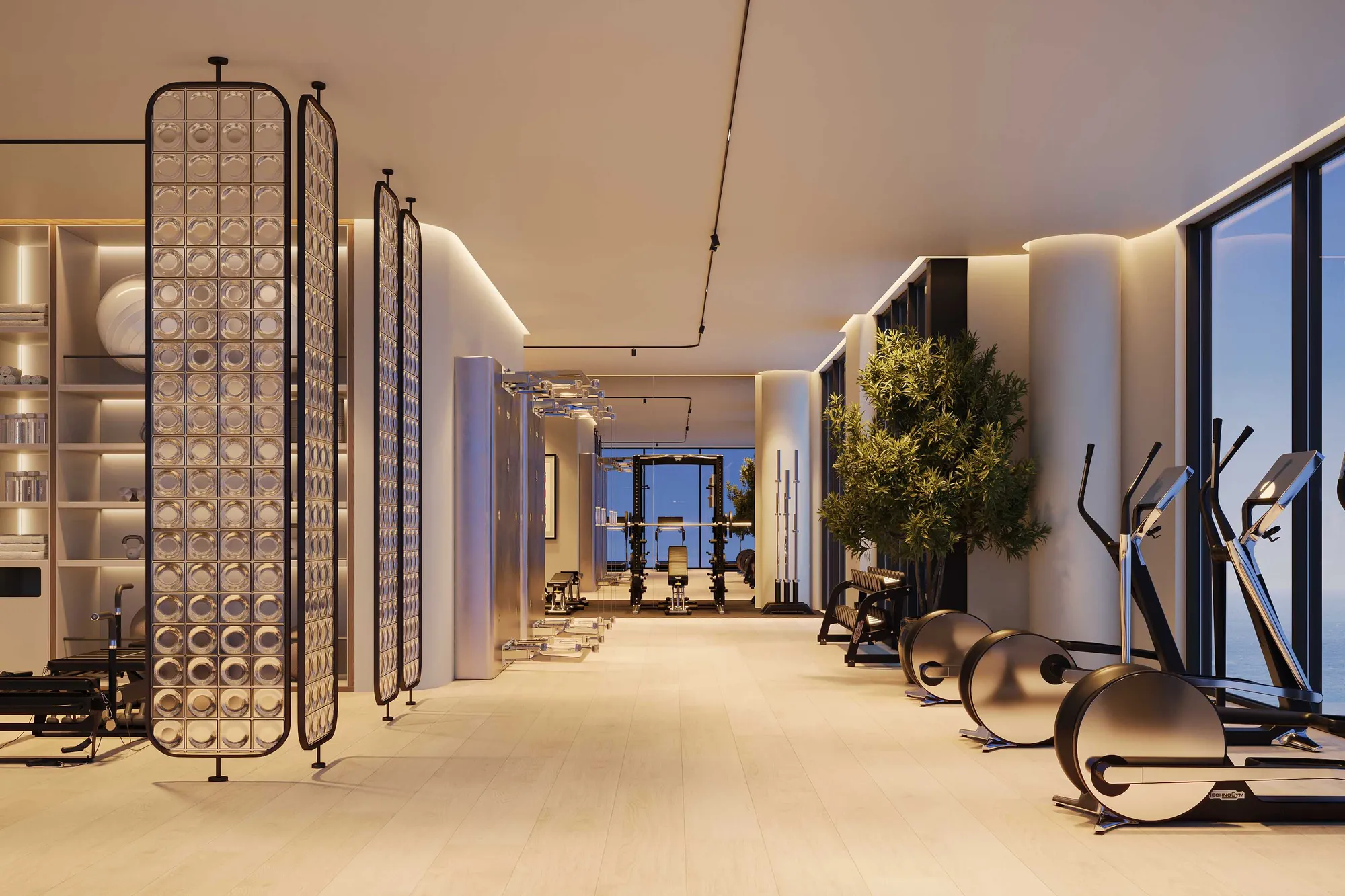 Fitness floor with Technogym machines and tall windows facing the sea